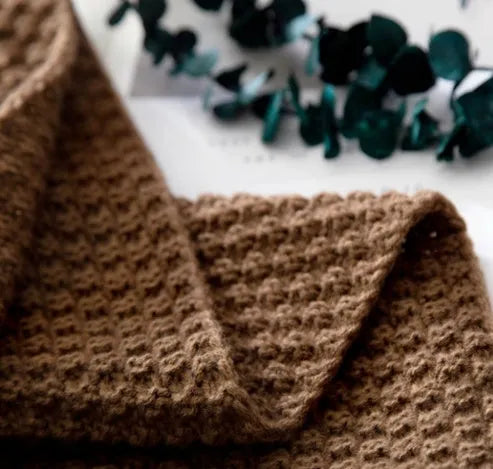 Fringed acrylic knit ball blanket 130x170cm in beige on a sofa