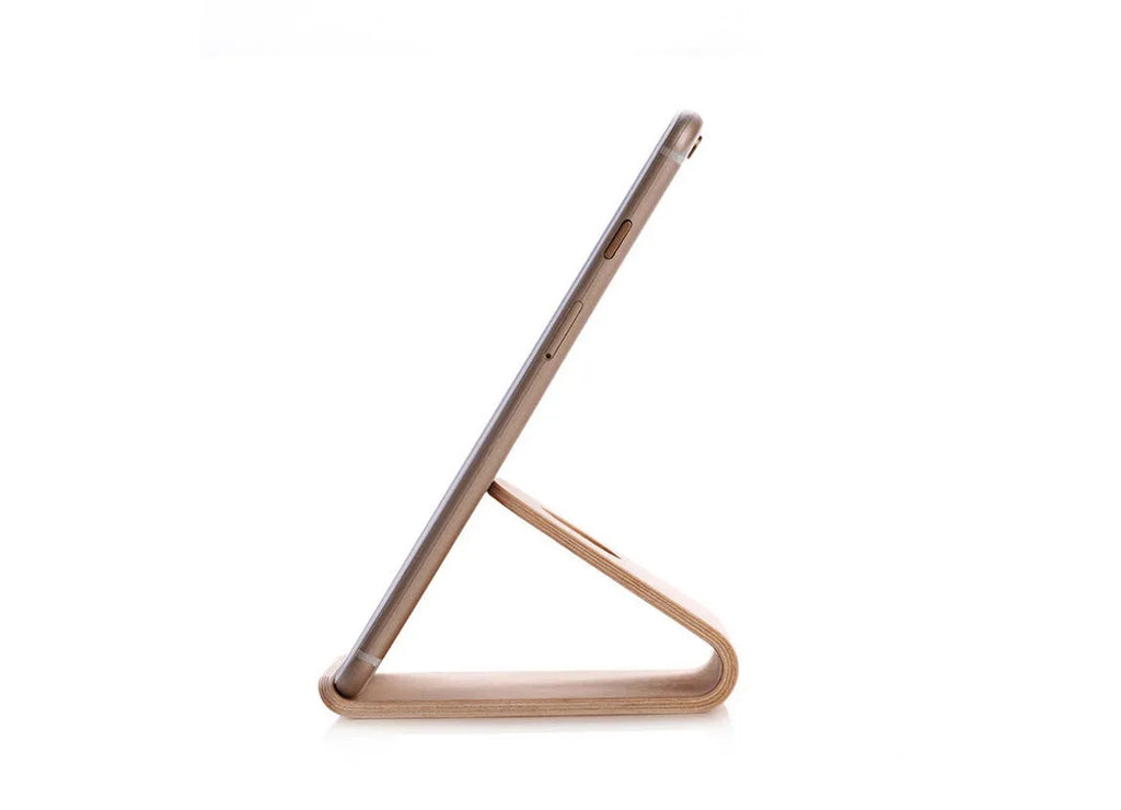 Solid wood iPhone stand in walnut finish on a desk