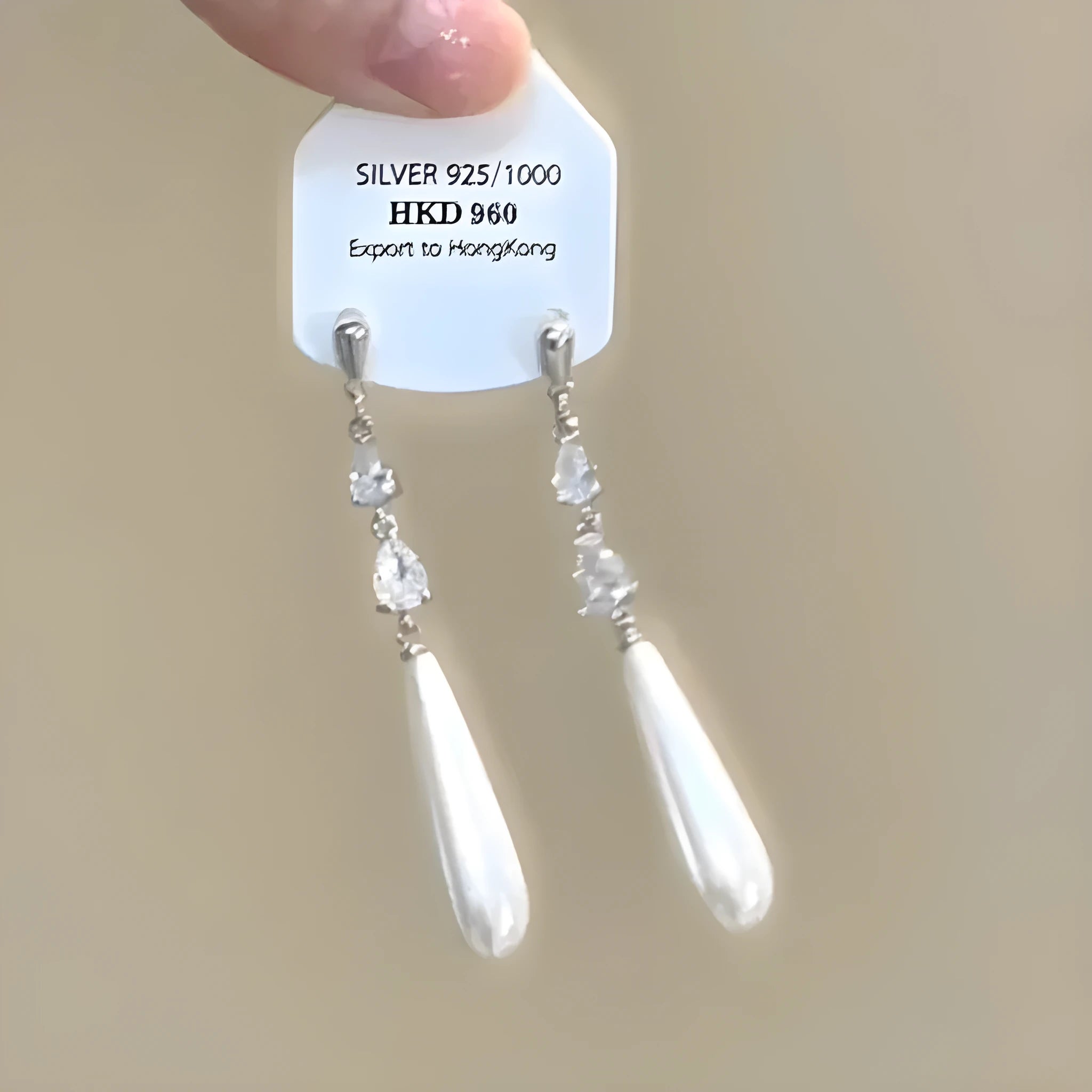 Geometric heart-shaped women's earrings with rhinestones and a silver tassel, shown on a white background.