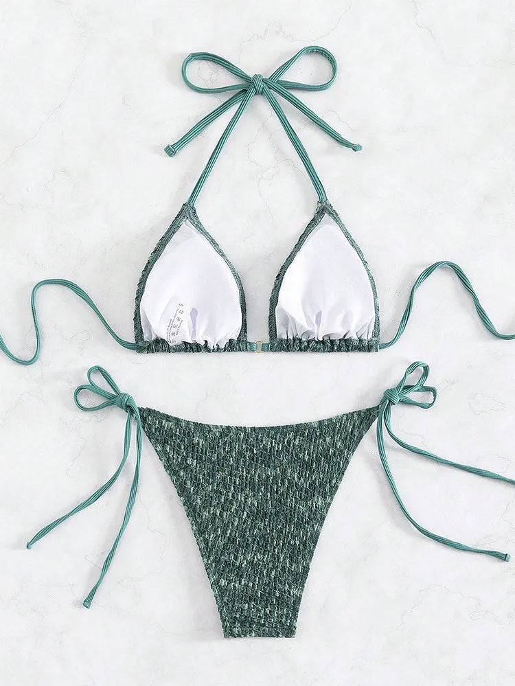 Green and pink women's backless halter swimsuit top and shorts set on a white background