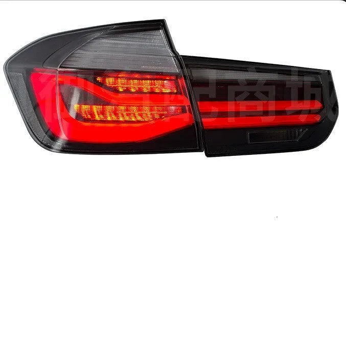 BMW 3 Series modified LED tail light assembly in smoked black finish, showing streamer light pattern.