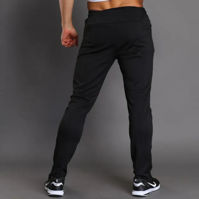 Slim-fit polyester running trousers with colour-changing reflective printing and zip pocket, black, front view
