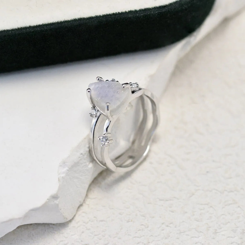 S925 silver geometric ring with irregular triangle shape and central moonstone on a model's hand.