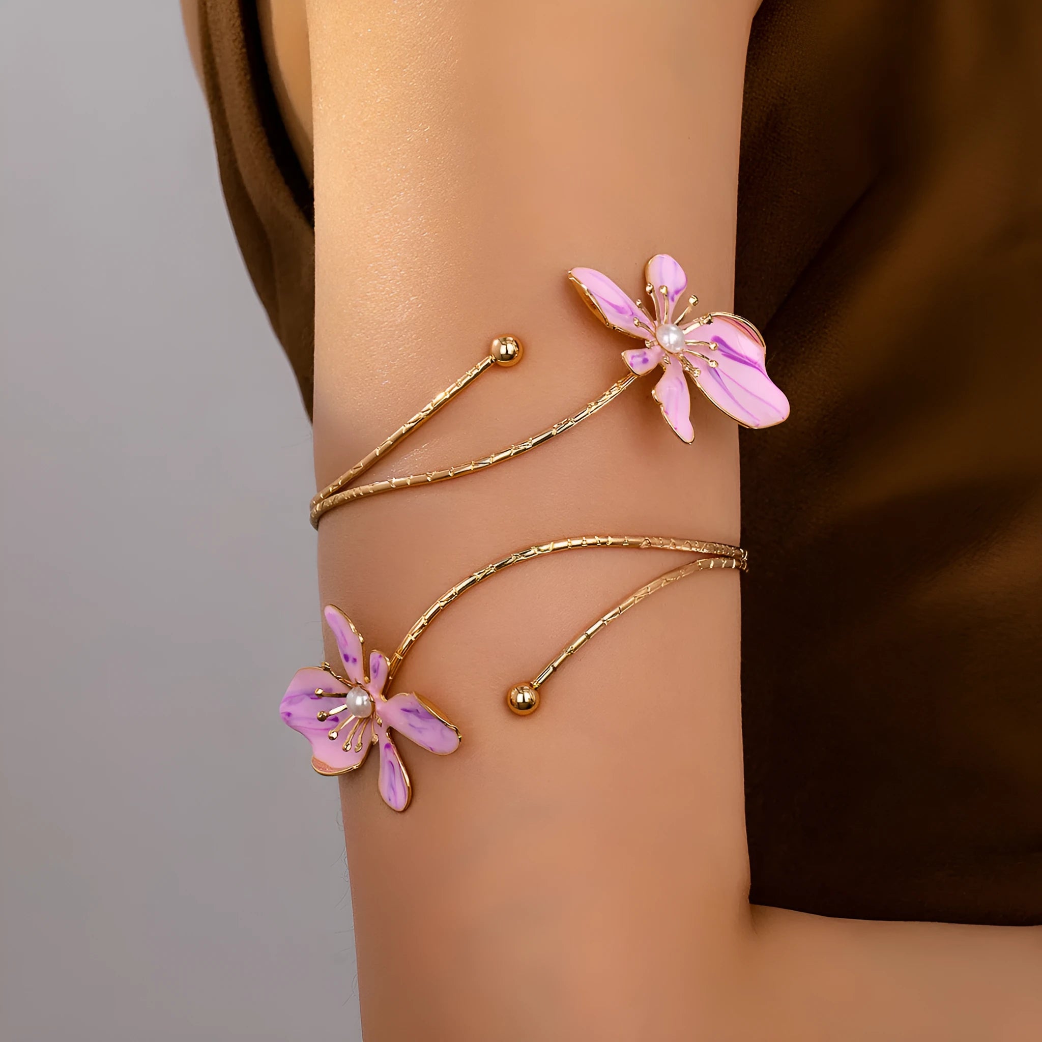 Close-up of a geometric hollow pattern alloy armband bracelet in pink, showing adjustable closure.