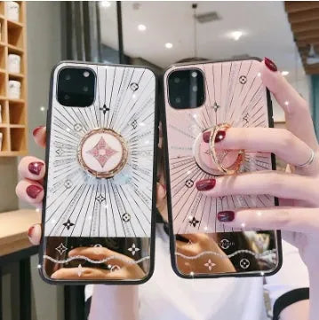 Luxury diamond and gold ring holder stand holding an iPhone for hands-free viewing.