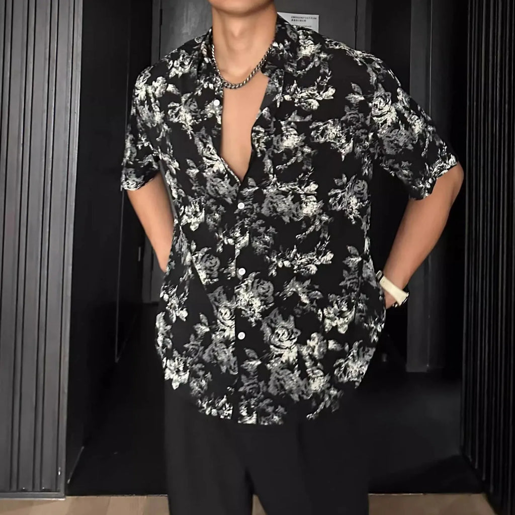 Man wearing a loose black floral print casual short sleeve shirt.