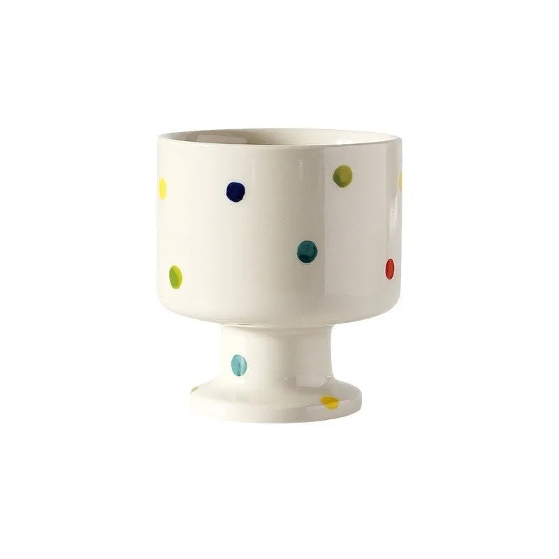Hand-pinched irregularly shaped ceramic mug in a solid colour, shown on a table.