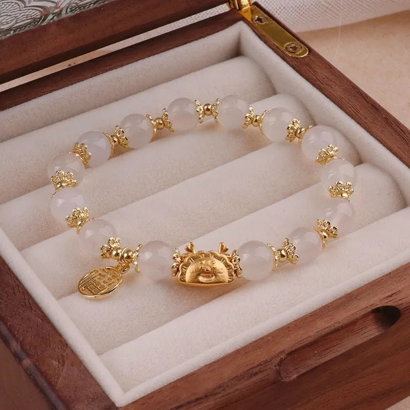 Women's floral glazed bracelet with ice crack texture and zodiac animal charm on wrist.