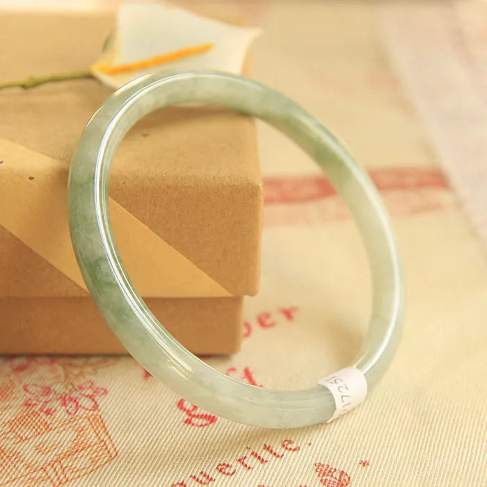 Green jade waxy geometric Chinese style bracelet showing 10mm width on wrist.