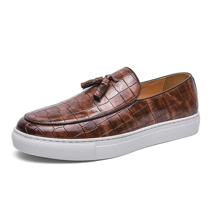 Men's black tassel slip-on sneakers with a round toe and rubber sole on a white background.