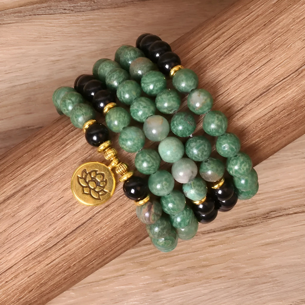 Green and black elastic beaded long bracelet with alloy components stretched on wrist