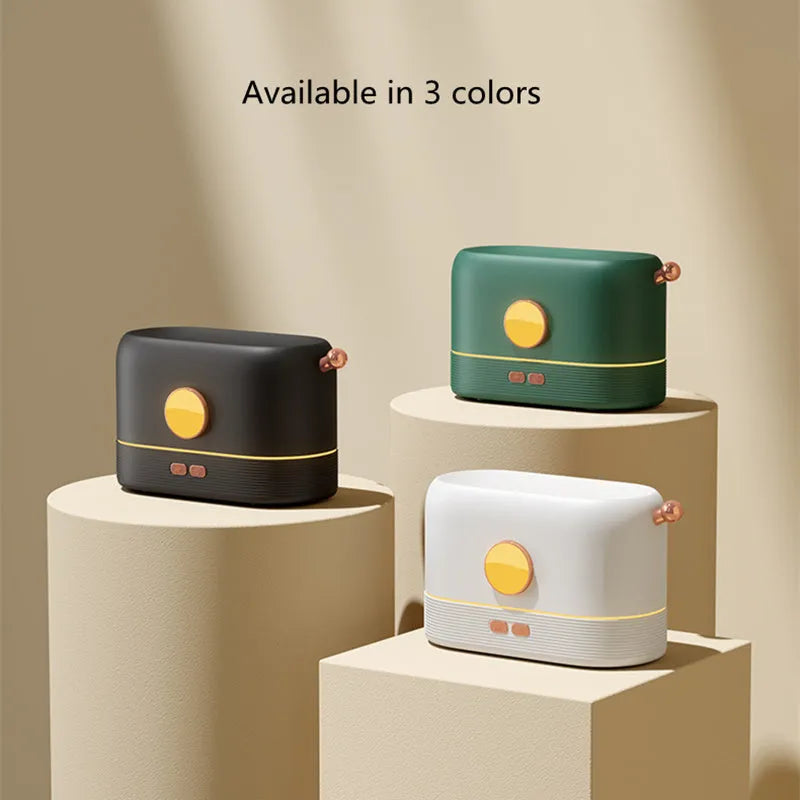 Black USB desktop humidifier with decorative orange flame effect and water tank on a wooden desk.