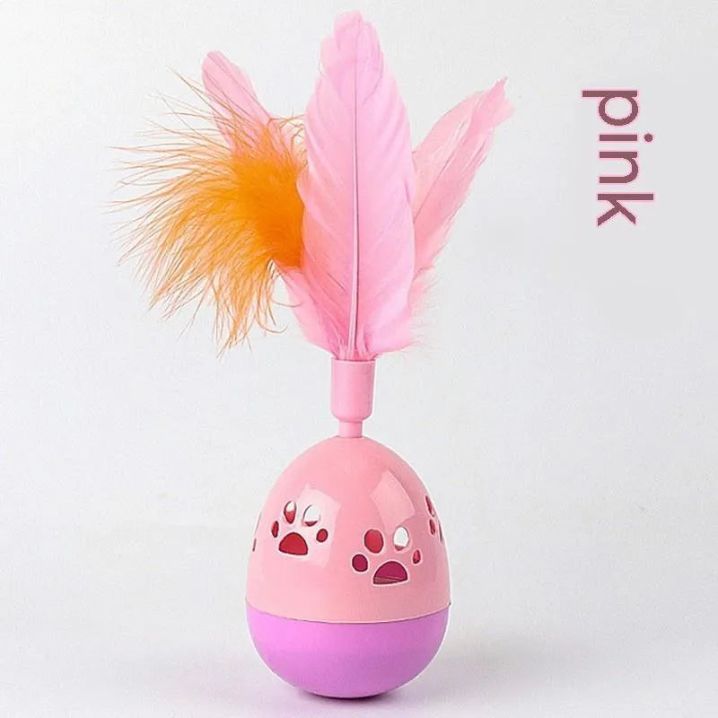 Green cat tumbler bell interactive toy with hollow footprints and feathers on a light floor