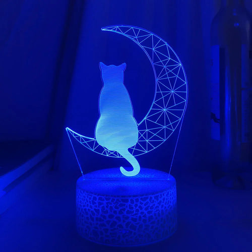 3D LED light moon and cat shape acrylic panel with remote control and USB cable on a dark surface