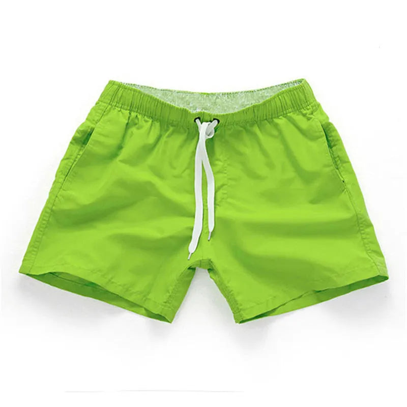 Men's black surf shorts made from polyester fabric with a straight leg opening, shown on a size chart.