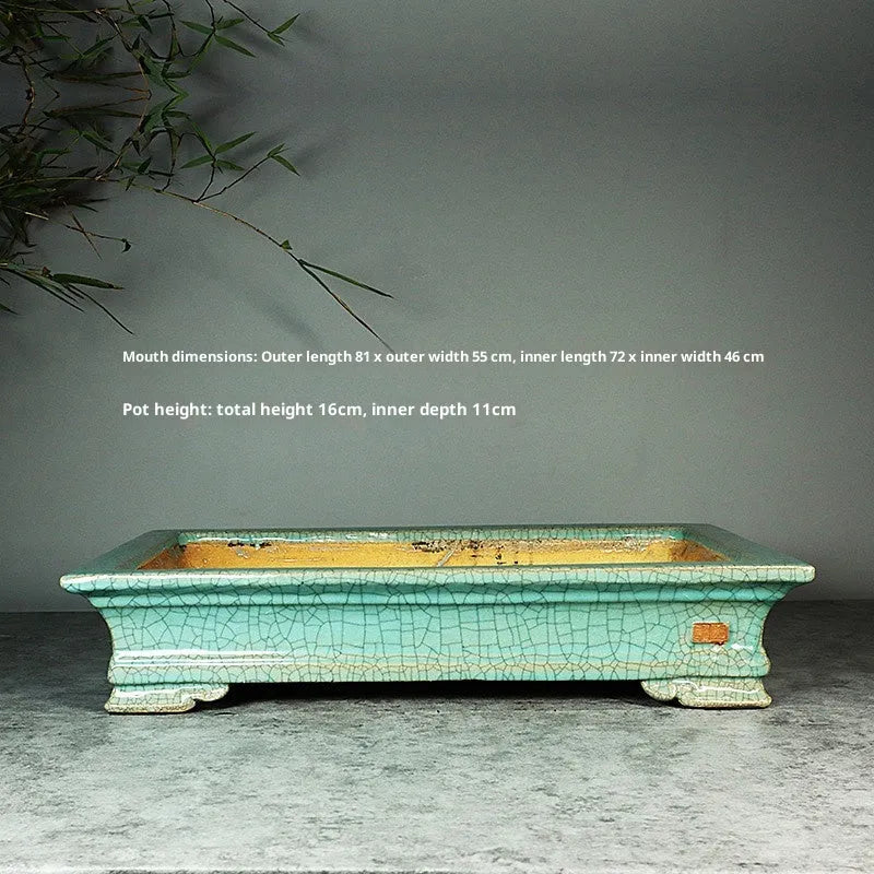 White cracked ceramic bonsai flowerpot with bamboo plant, manual purple sand craft