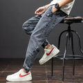 Man wearing loose blue cargo jeans with straight leg and mid waist.