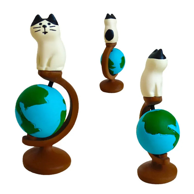 Cartoon resin craft sculpture of a cat dressed as the Statue of Liberty, holding a globe.