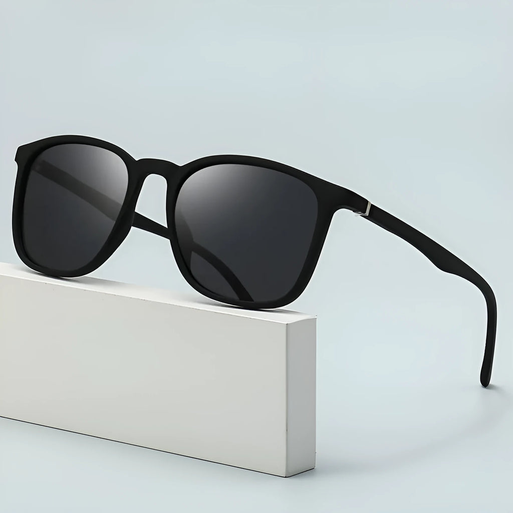 Men's polarised sunglasses with a black frame and dark green lens, showing PC construction and elastic paint finish.