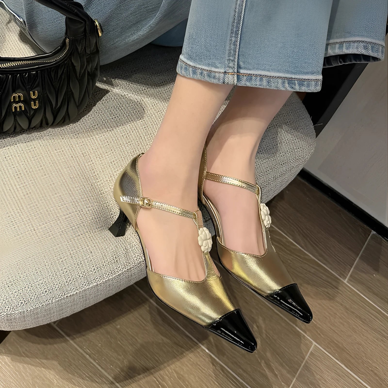Gold women's stiletto heel shoe with floral buckle and pointed toe on a shallow 7-11cm cut.