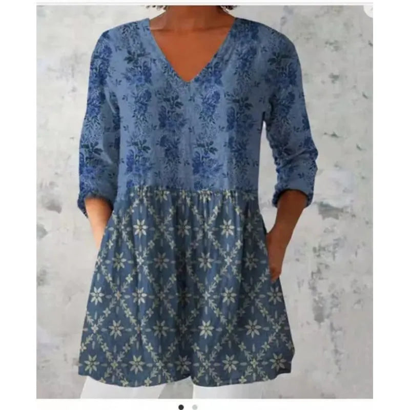 A woman wearing a loose-fitting printed dress with 3/4 sleeves and a wide waist.