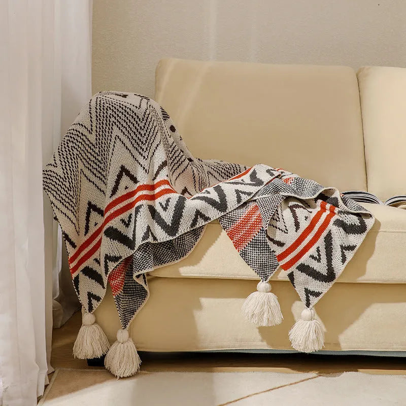 Acrylic sofa blanket with tassel fringe in geometric pattern, showing 130 cm width measurement