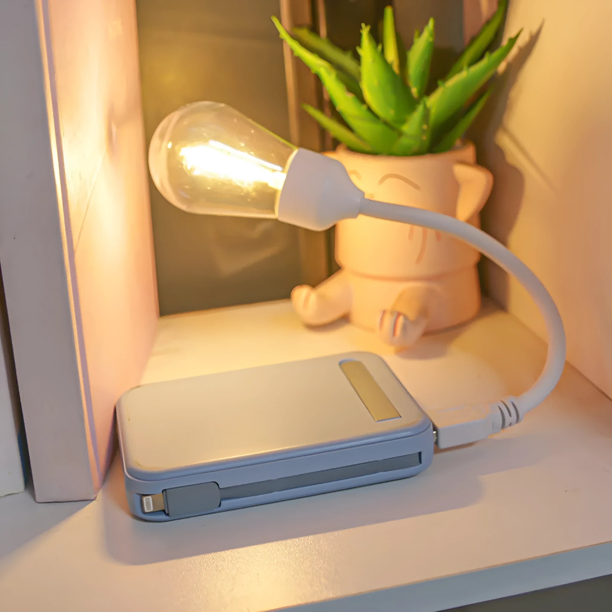 USB rechargeable folding night light with a glowing tungsten filament bulb on a table.