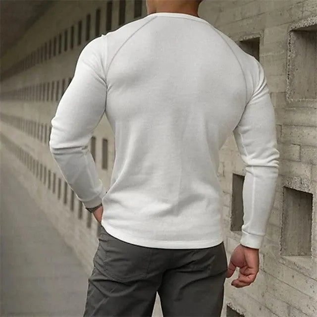 Man wearing a navy blue long-sleeved t-shirt with a Henry collar.