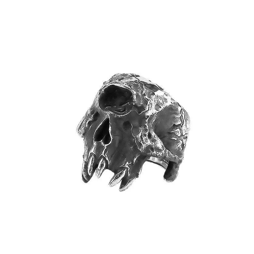 Close-up of a silver-toned alloy ring with a raised one-eyed skull design on a black background.