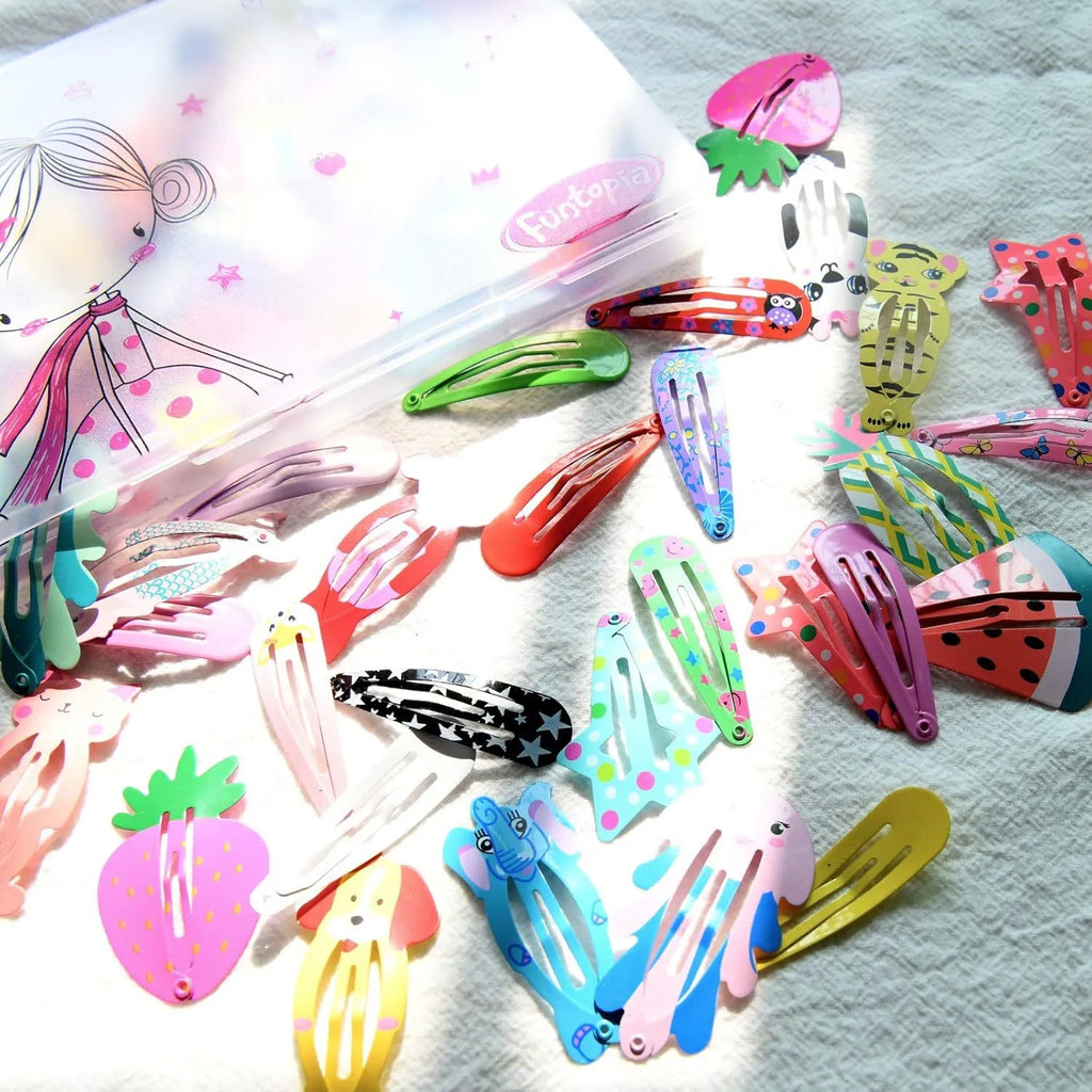 100 piece assortment of colourful metal snap hair clips with cartoon designs including animals, fruits, crowns, and stars.