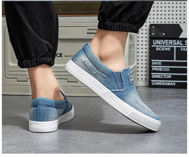 Slip-on canvas work shoes in dark blue with round toe and rubber sole on a plain background