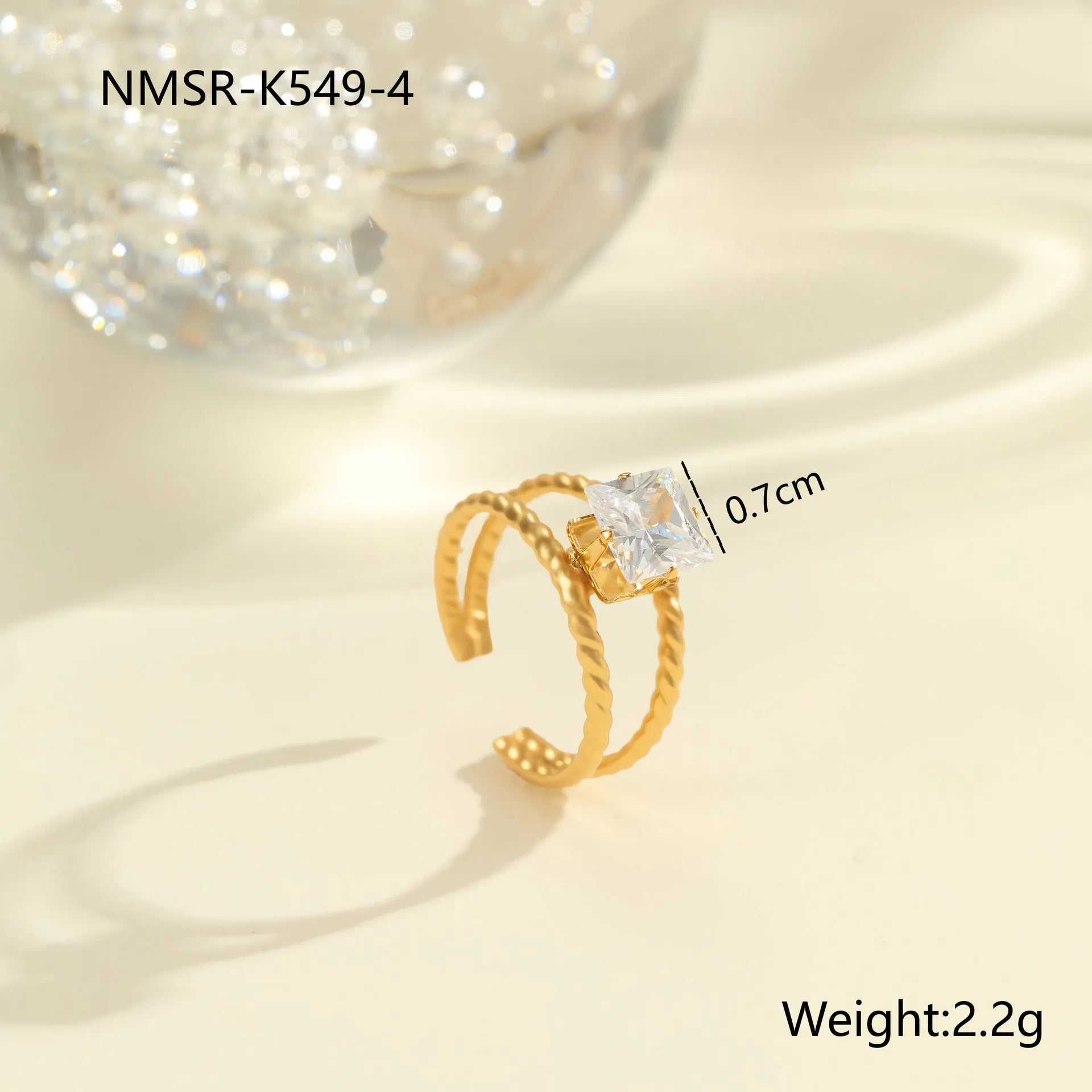 Gold-coloured adjustable stainless steel ring with zircon geometric shapes on white background.