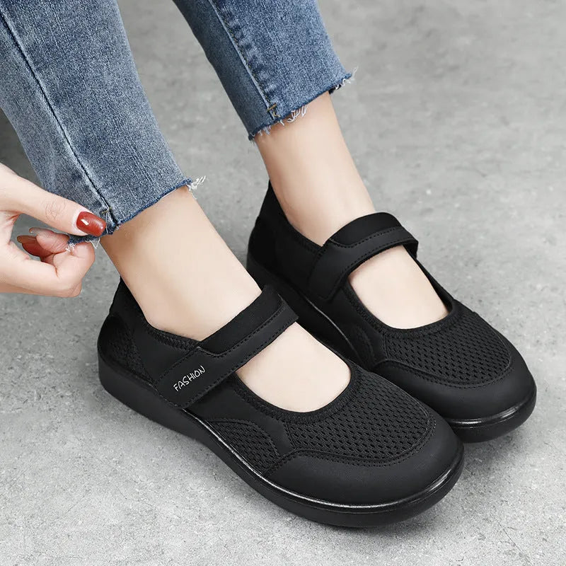 Women's low-top grey mesh sneakers with Velcro straps on a flat polyurethane sole.