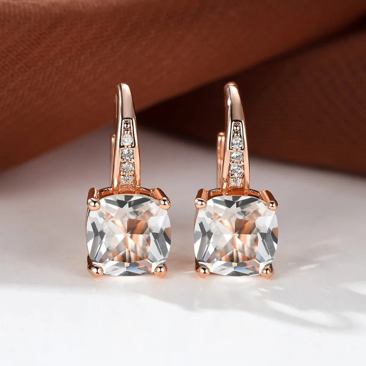 Square geometric ear hook studs with a round zircon stone, shown in a gold electroplated finish.