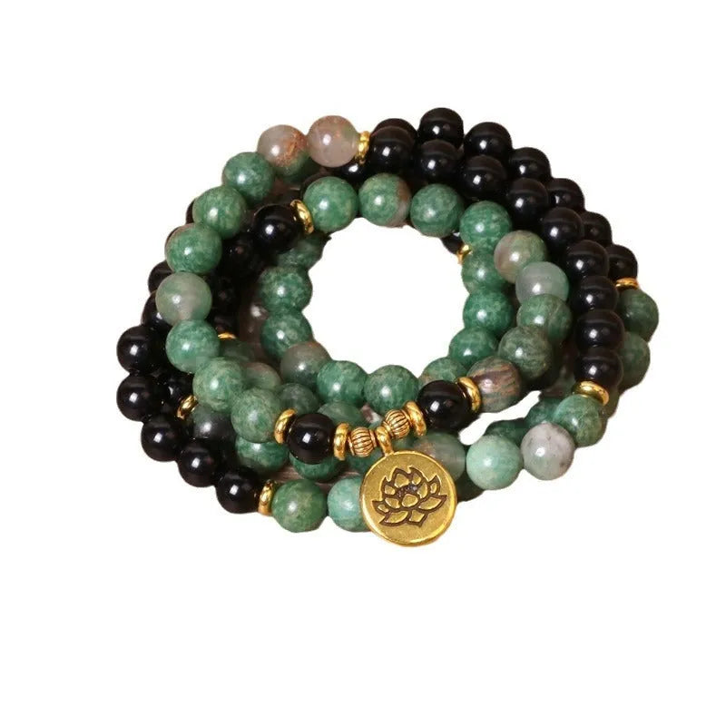 Green and black elastic beaded long bracelet with alloy components stretched on wrist