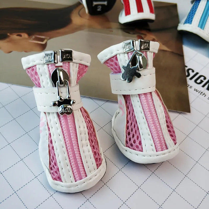 Four blue cloth dog shoes with zipper closures, shown on a small dog's paws.