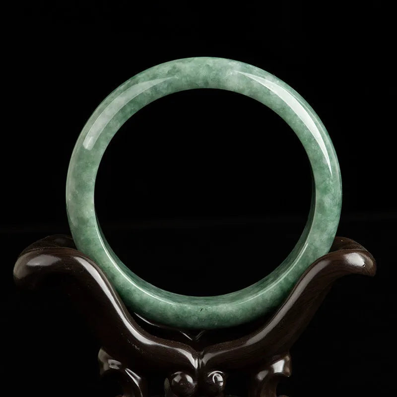 A simple deep pea green women's bracelet shown with a gift box and certificate.