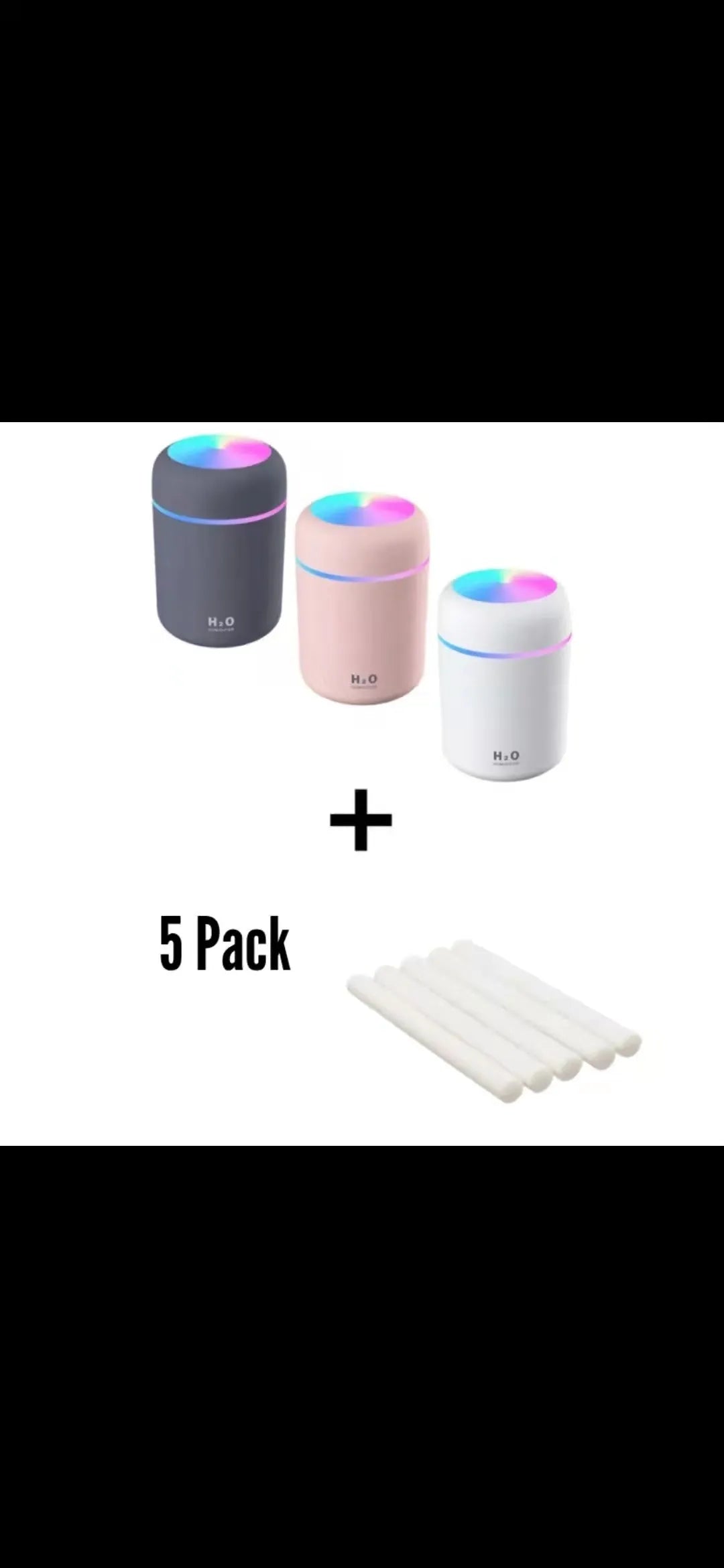 Pink USB desktop humidifier with LED lights and water tank on a wooden desk.