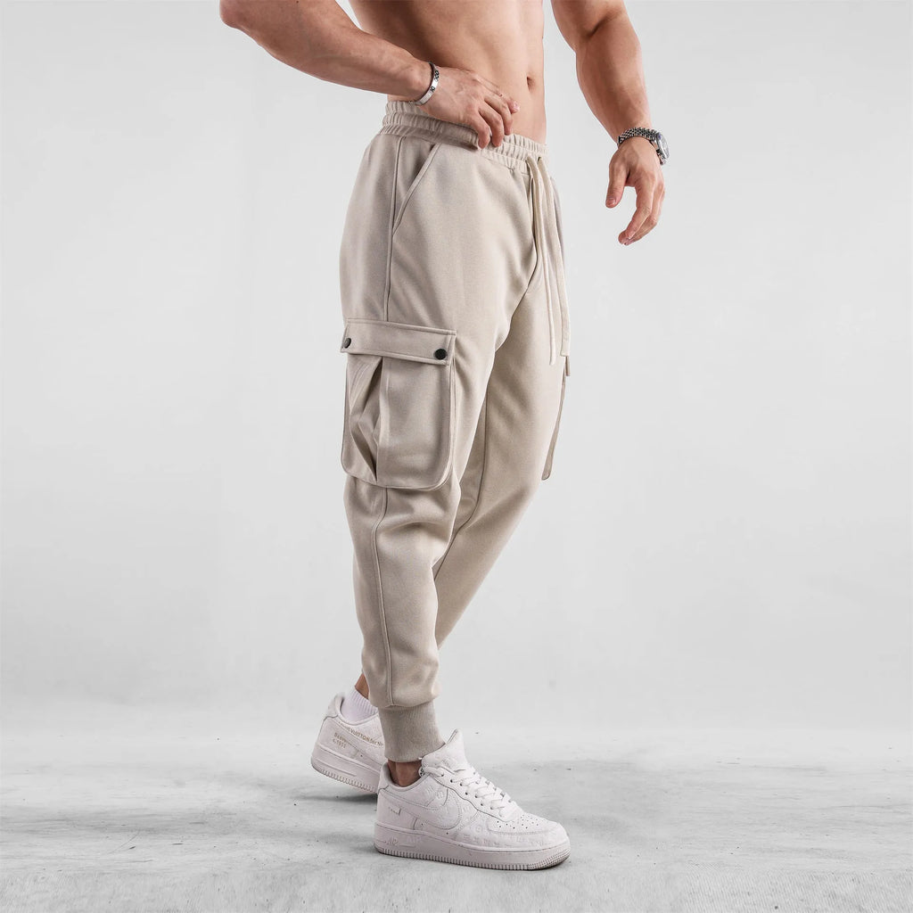 Men's loose-fit light grey cotton sports trousers with ankle tie and side pockets.