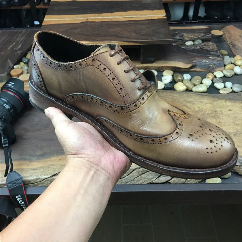 Light brown vintage engraved men's lace-up leather shoes with distressed finish and round toe.