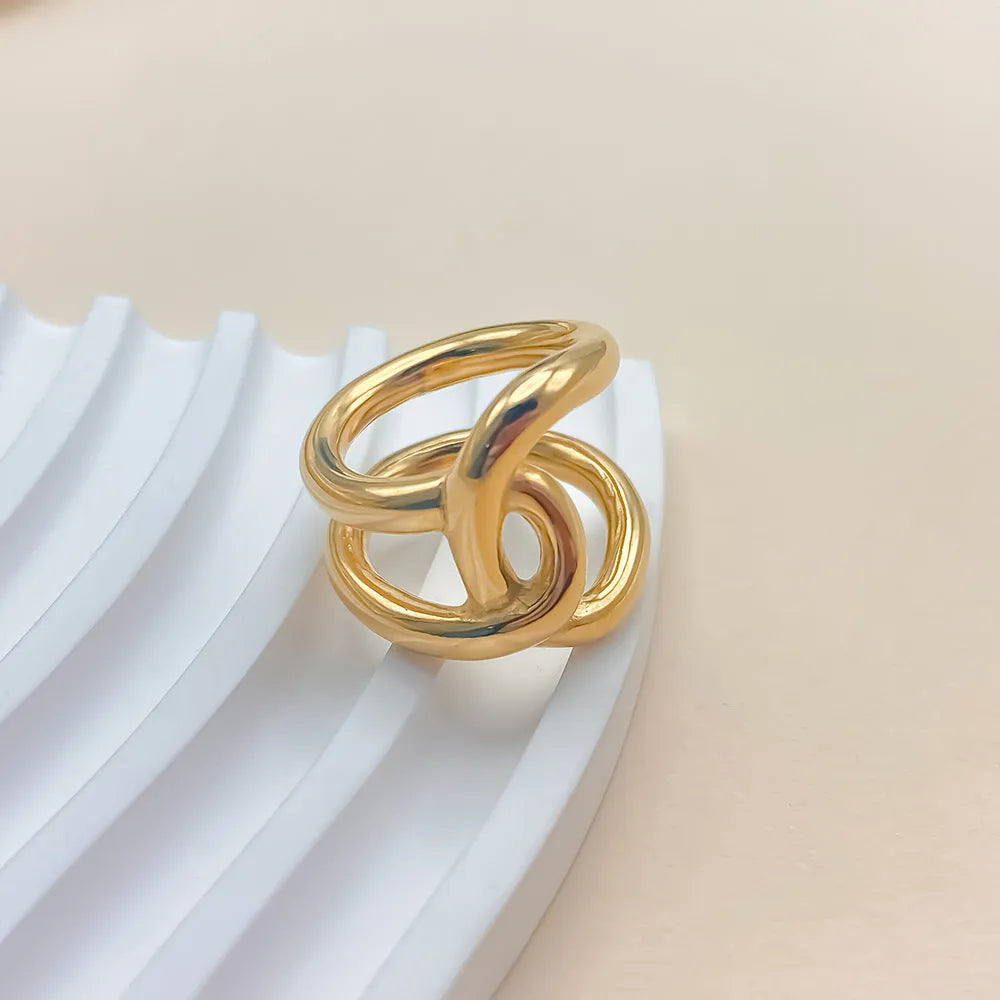 Women's stainless steel adjustable opening ring with a geometric knot design in gold colour.