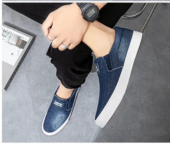 Slip-on canvas work shoes in dark blue with round toe and rubber sole on a plain background