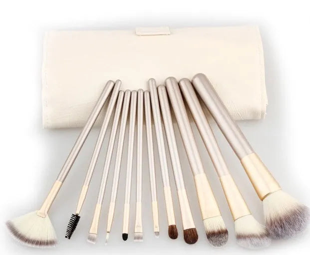 Champagne white synthetic fibre makeup brush set with wooden handles and aluminium ferrules on flat surface