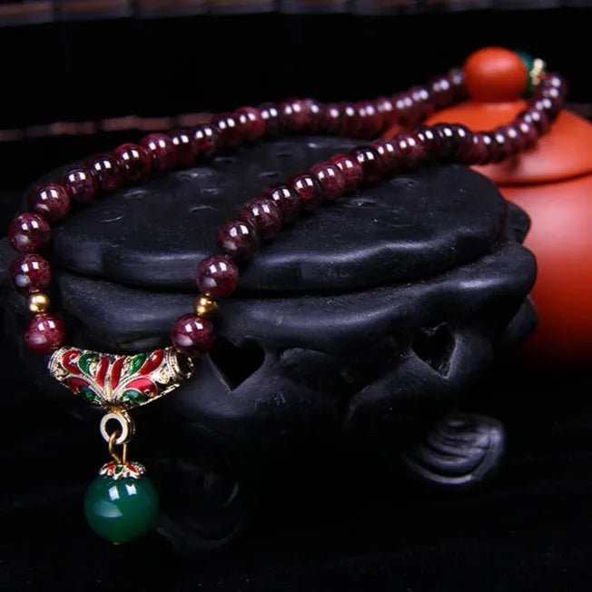 Natural garnet bracelet with 7mm beads and golden toad design on wrist