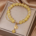 Natural citrine stone bracelet with an electroplated Chinese character tassel charm.