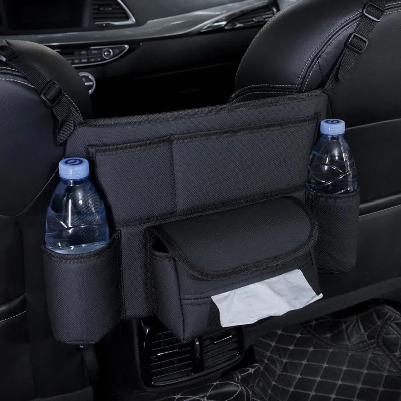 Black leather car interseat storage bag holding a tissue box, hanging between vehicle front seats.