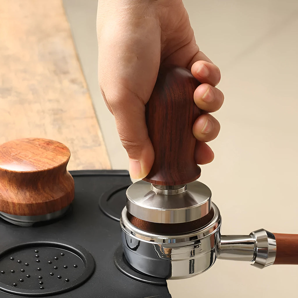 Black silicone coffee tamper pad with stainless steel base for non-slip espresso preparation