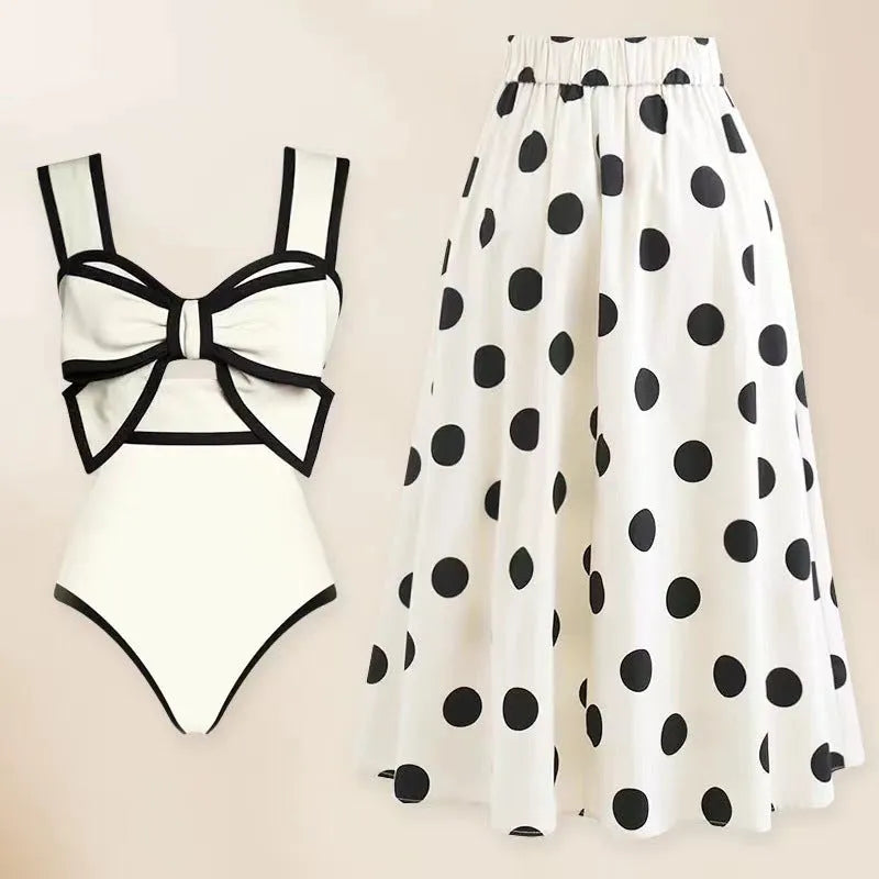 Women's black one-piece swimsuit with a white bow and attached round skirt.