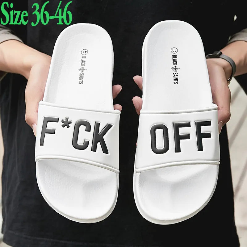 Men's black open toe slippers with a rubber sole on a wooden floor.