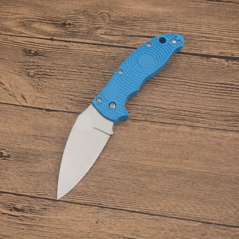 Portable folding fruit knife with black handle and silver 9CR13MOV blade on a wooden surface